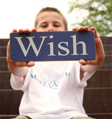 Young boy holding a sign that says wish