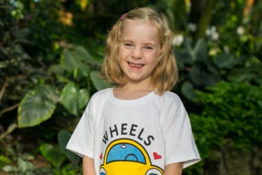 Clara smiling in Wheels For Wishes shirt