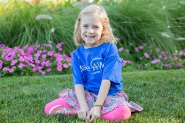 Clara smiling in Make-A-Wish shirt