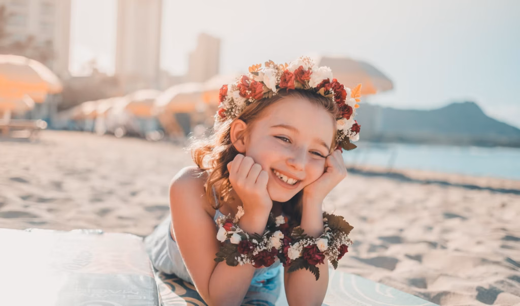 Smiling girl with flowers on beach