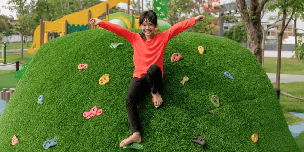 Child playing on grassy hill at a park in the Bay Area.
