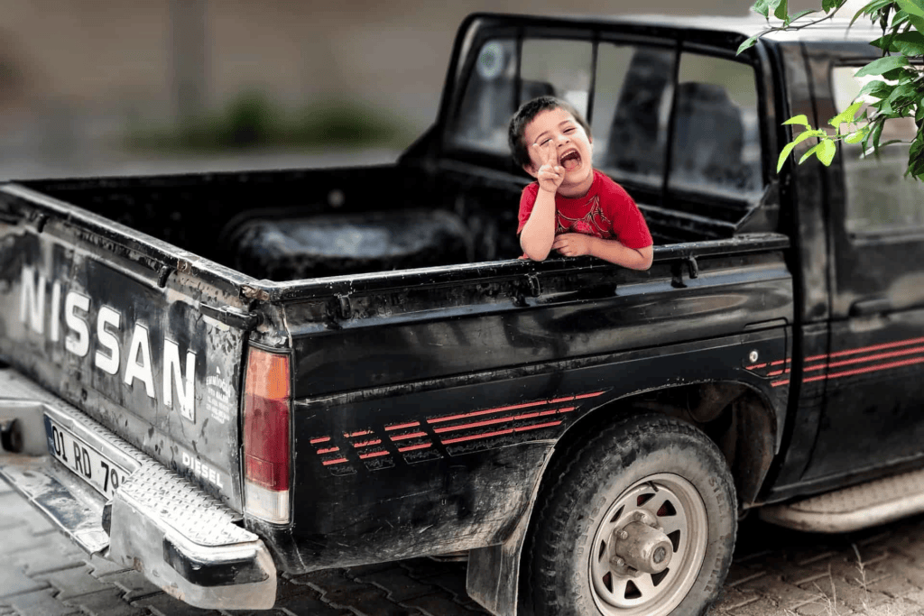 boy in back of Nissan truck being donated