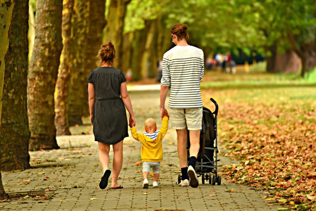 father, mother and son holding hands and walking in Autumn in Norristown, PA