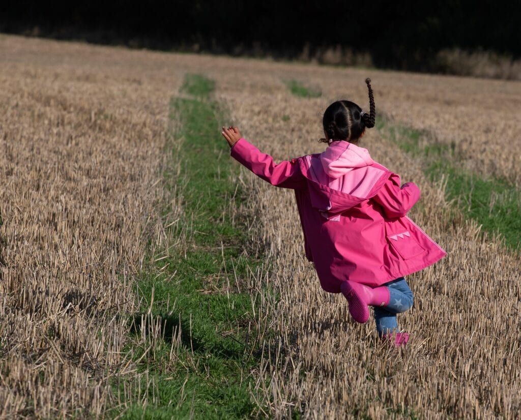 little girl running through field in Clarkstown, NY